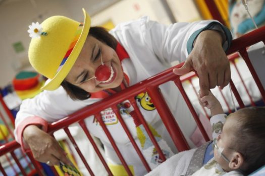 A performer dressed as a clown doctor visits a child in a Mexican hospital. Pascal Lauener/Reuters